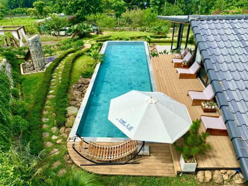 widok na basen z parasolem w obiekcie A Little Hill Retreat w mieście Hòa Bình
