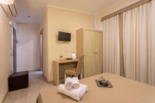 a hotel room with two beds and a desk at Hotel Belvir in Villasimius
