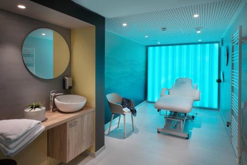 uma casa de banho com um lavatório e um espelho em DOMITYS LYON LA MANUFACTURE em Lyon