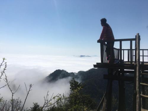 una persona parada en la cima de una plataforma mirando las nubes en A La Homestay en Hòa Bình