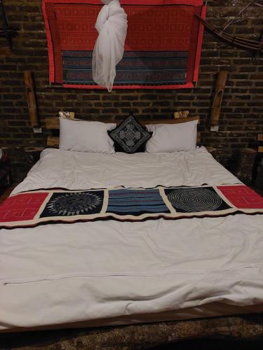 1 cama blanca grande con mantas y almohadas en A La Homestay en Hòa Bình