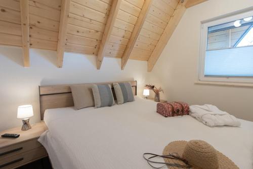 um quarto com uma grande cama branca e uma janela em MP 18 - Strandvogt 3 Komfort em Dorum Neufeld