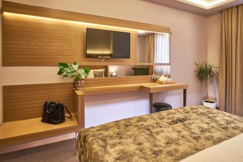 Habitación de hotel con cama y TV de pantalla plana. en Atro Hotel en Estambul