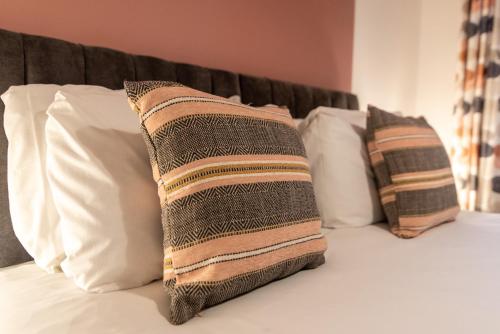 3 almohadas sentadas encima de una cama en Newark Apartments: Ideal for Contractors with Parking en Balderton