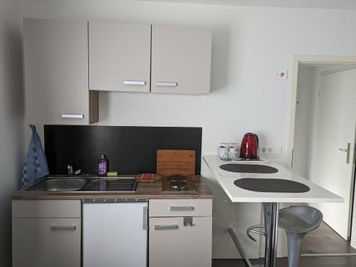 a kitchen with white cabinets and a counter top at Hotel Ari in Kaiserslautern