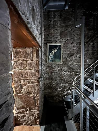 a staircase in a stone building with a picture on the wall at The Church Tower in Crieff