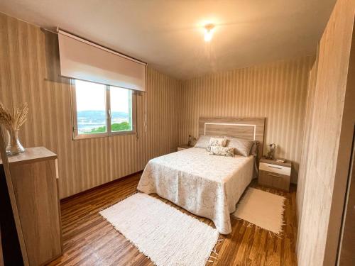 a bedroom with a white bed and a window at Casa de campo in Pontevedra