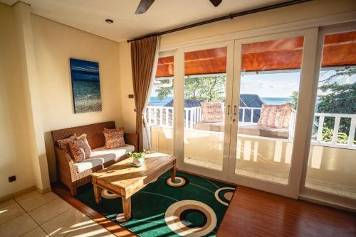 a living room with a couch and a table at Tauch Terminal Resort Tulamben & Spa in Tulamben
