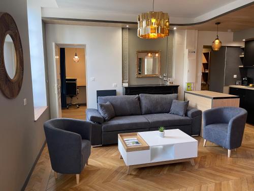 Superbe F3 meublé , hyper centre, fibre, idéal Pro في مونلوسون: غرفة معيشة مع أريكة وكراسي وطاولة