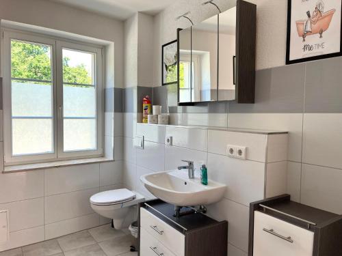 a white bathroom with a sink and a toilet at Frisch freche 3 R Ferienwohnung in Dohna