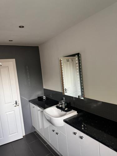 een badkamer met een witte wastafel en een spiegel bij "Tranquil Village Hideaway Bungalow"near Kings Lynn in Kings Lynn