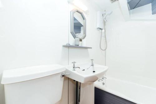 a white bathroom with a sink and a mirror at Valley View at Clauchan Holiday Cottages in Gatehouse of Fleet