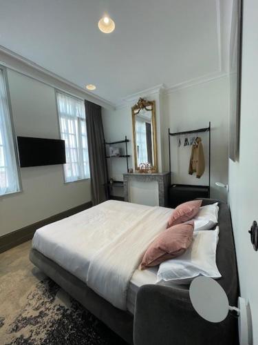 a bedroom with a large bed with pillows on it at Maison Manotte d’Artois in Arras