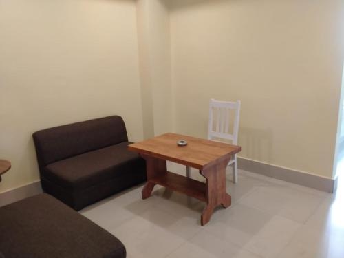 um quarto com um sofá, uma mesa e uma cadeira em HOTEL NL7 em Dimāpur