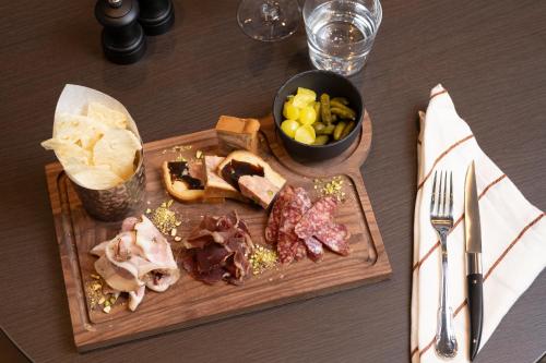 una tabla de cortar con carne y hortalizas sobre una mesa en Brussels Marriott Hotel Grand Place, en Bruselas