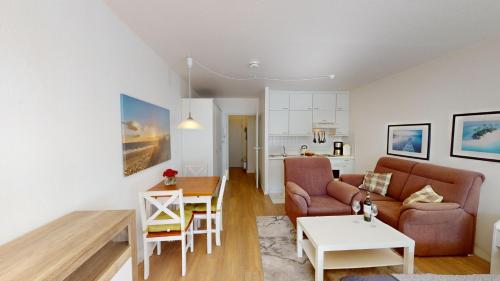 uma sala de estar com um sofá e uma mesa em NeuKlosterhof App. 06 em Pelzerhaken