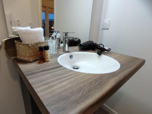 un bancone del bagno con lavandino bianco su un piano di lavoro di Zenao Appart'hôtels Montivilliers a Montivilliers