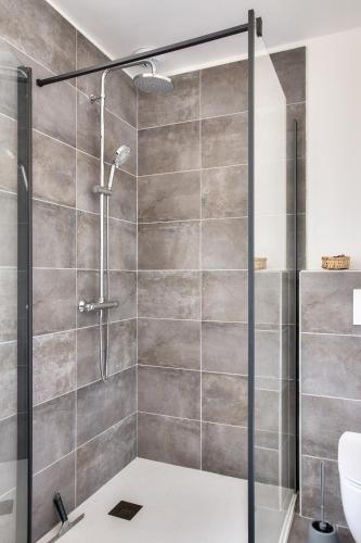 une douche avec une porte vitrée dans une salle de bain dans l'établissement Maison avec jardin pour 5 à Penmarch, à Penmarcʼh