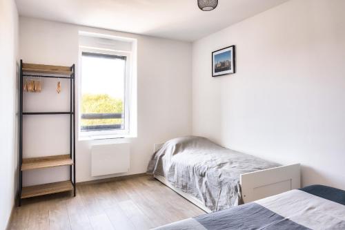 une chambre avec un lit et une fenêtre dans l'établissement Maison avec jardin pour 5 à Penmarch, à Penmarcʼh