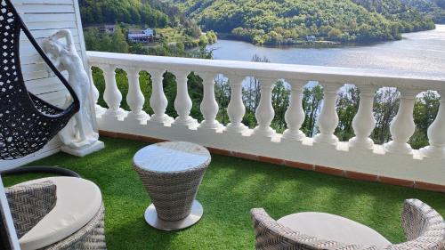 a balcony with chairs and a view of the water at Ma villa au bord de l'eau in Miremont
