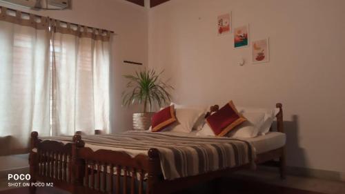 um quarto com uma cama com almofadas e uma janela em The Clift em Varkala