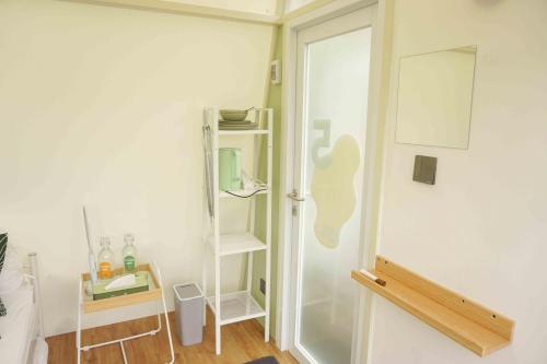 a room with a white door and a shelf at Over Easy Glamping Site in Bandung