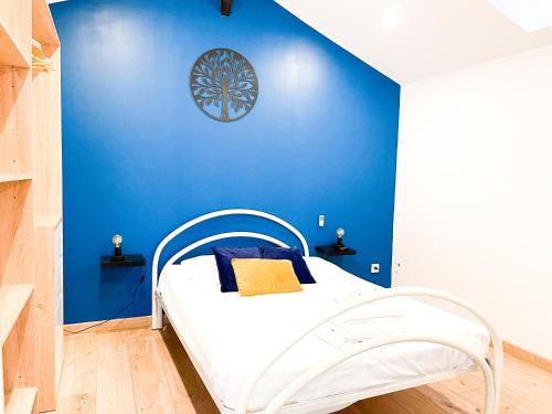 Un dormitorio con una pared azul y una cama en "City House" - Maison de ville - centre ville - T3 - BY PRIMO C0NCIERGERIE, en Mâcon