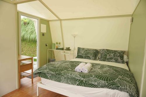 ein Bett mit zwei Kissen darauf in einem Schlafzimmer in der Unterkunft Over Easy Glamping Site in Bandung