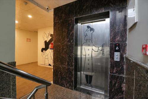 een lift in een gebouw met een muurschildering van een vrouw bij Hotel Chaitanya Stay in New Delhi