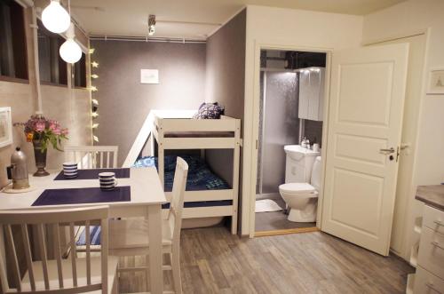 eine kleine Küche mit einem Tisch und ein Badezimmer mit einem WC in der Unterkunft The Blueberry Inn in Rovaniemi
