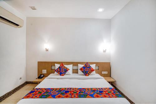 a bedroom with a large bed with colorful pillows at FabExpress Vasundhara Suits in Ghaziabad