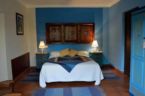 a bedroom with a bed with blue walls and two lamps at Granja de Cantarinas in Ciudad-Rodrigo