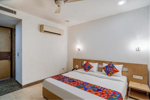 - une chambre avec un grand lit et des oreillers colorés dans l'établissement FabExpress Vasundhara Suits, à Ghaziabad