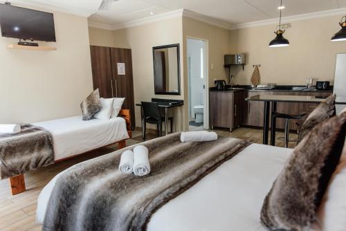 um quarto de hotel com duas camas e uma cozinha em Casa Leitao Lodge em Phalaborwa