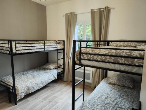 Cette chambre comprend 3 lits superposés et une fenêtre. dans l'établissement Le Cottage Senlisien, à Senlis
