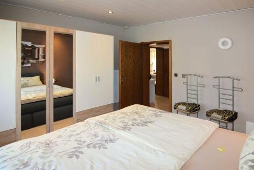a bedroom with a large bed and two chairs at Schneckenhütte in Meschede