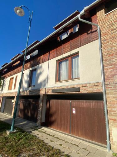 un bâtiment avec une porte de garage marron et un éclairage de rue dans l'établissement Angyal Apartman Gyula, à Gyula