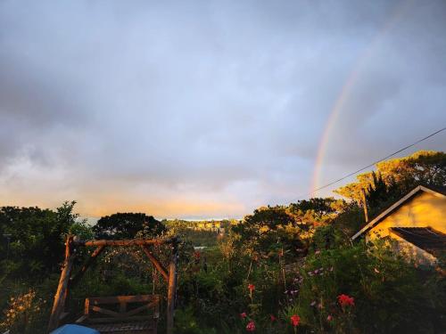 a rainbow in the sky over a garden with flowers at Romantic house 2 on a pine hill Dalat in Da Lat