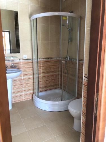 uma casa de banho com um chuveiro, um WC e um lavatório. em ART inn hotel em Baku