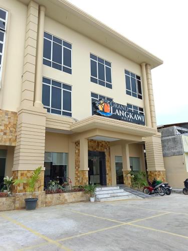 Grand Langkawi hotel aceh في Lheue: موقف امام مبنى كبير
