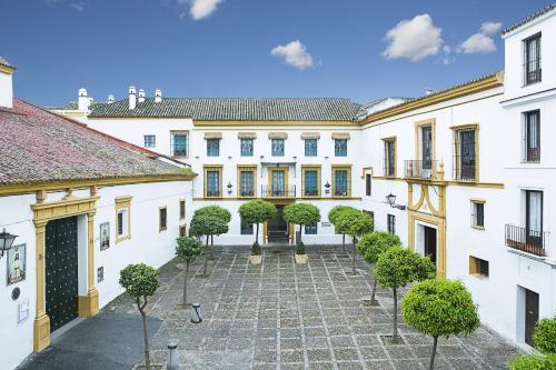 an exterior view of a building with a courtyard at Hospes Las Casas Del Rey De Baeza in Seville