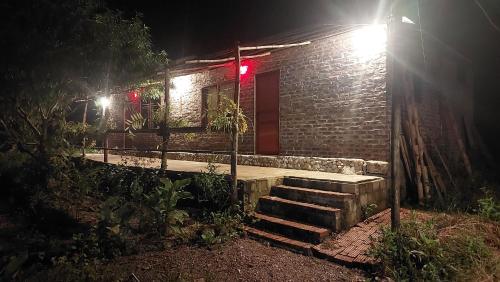 Una casa de ladrillo con escaleras delante de ella por la noche en A La Homestay, en Hòa Bình