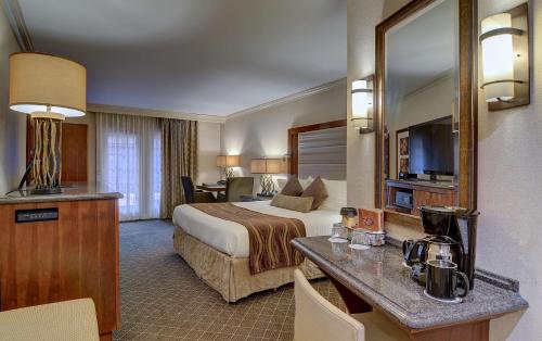 a hotel room with a king sized bed and a desk at Eden Resort and Suites, BW Premier Collection in Lancaster