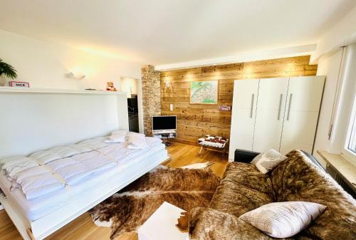 - une chambre avec un grand lit et un canapé dans l'établissement Chalet-Studio, à Loèche-les-Bains