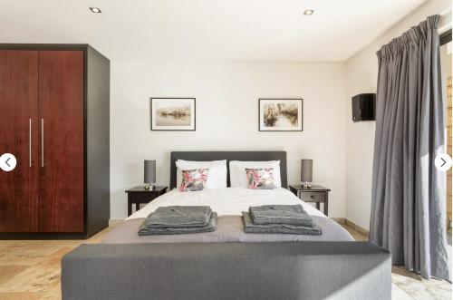 a bedroom with a large bed with two pillows at Watch the Sun Rise in Cape Town