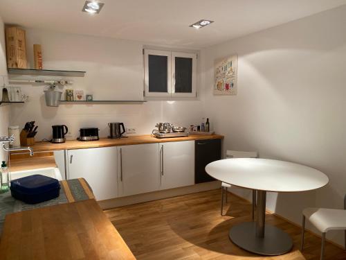 uma cozinha com uma mesa e uma mesa branca em Ruhiges WG-Appartment in Einfamilienhaus em Glashütten