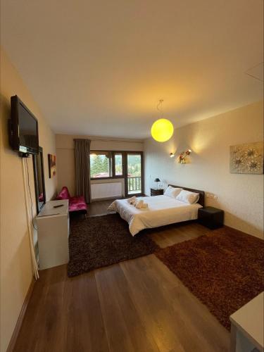 Habitación grande con cama y TV. en 7Hills by Life Houses, en Eptalofos