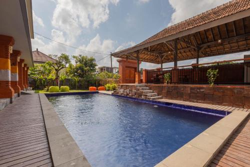 a swimming pool in front of a house at Candra Loka Studio & Apartment by The Loka in Kerobokan