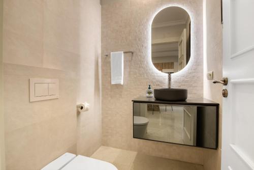 La salle de bains est pourvue d'un lavabo, d'un miroir et de toilettes. dans l'établissement Bungalow Villa Gadea, à Altea