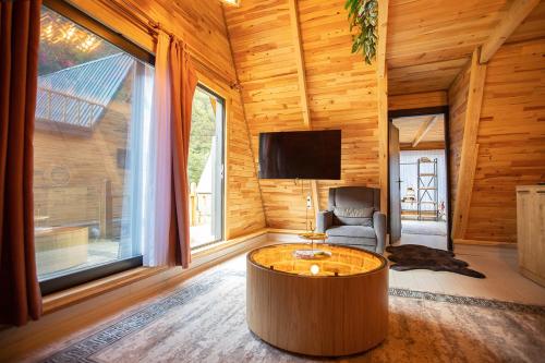 una sala de estar con una mesa redonda de café en una cabaña de madera en TERAPİ TATİL KÖYÜ, en Rize